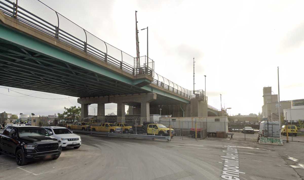 Bridge over concrete roadway with cars and trucks
