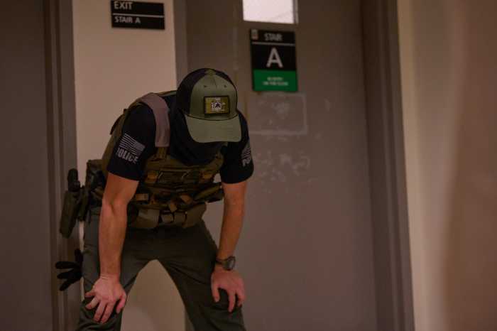 a law enforcement officer in uniform with his hands on his knees