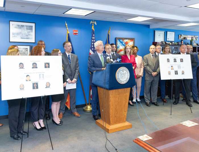 a group of people in a room behind a podium discussing a NYS DMV scam