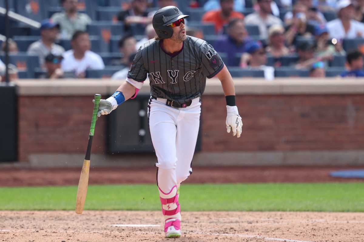 Jeff McNeil Mets: Man in grey baseball uniform drops bat after hitting a single.