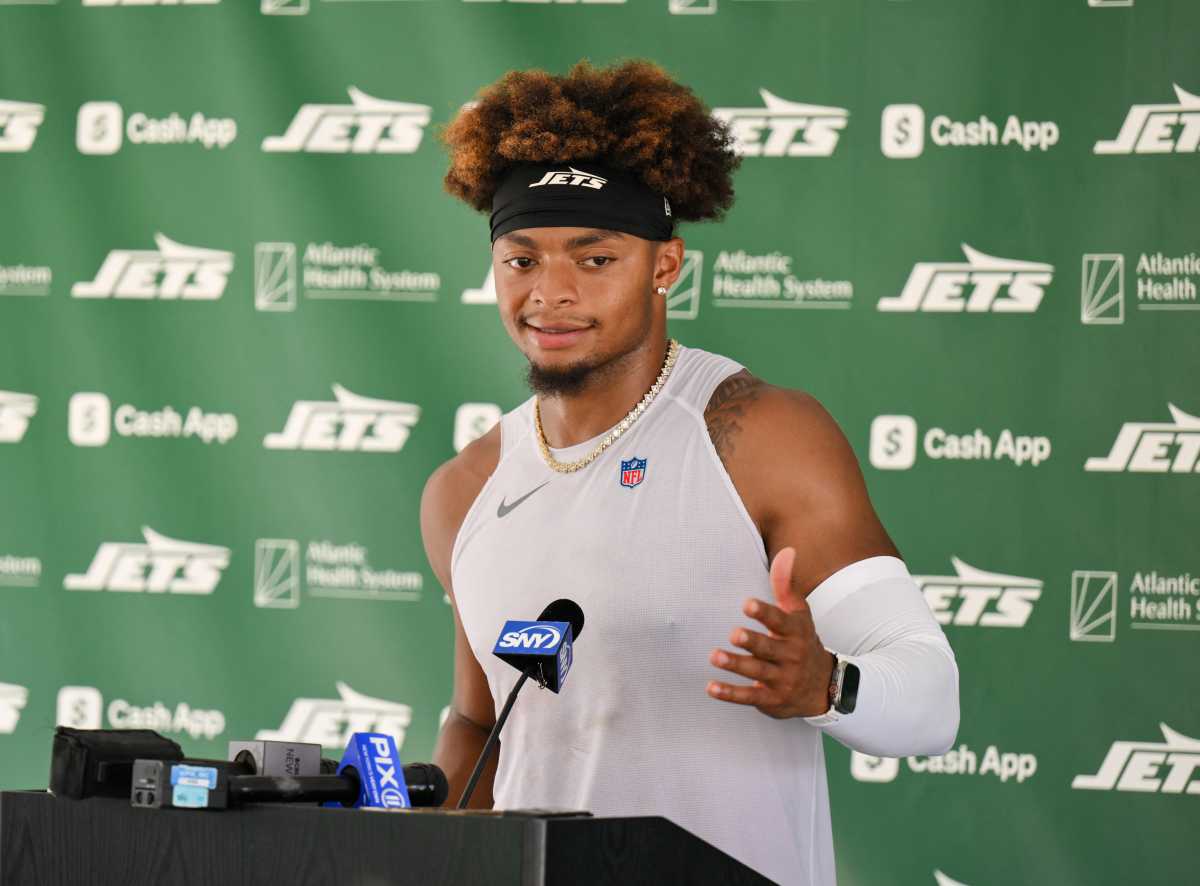 Jets get a training camp scare as QB Justin Fields dislocates toe 2 Man in front of Jets banner green and white speaking in front of microphone