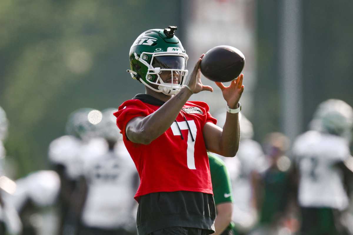 Jets ditch norms, go full contact early in training camp to forge tougher team identity 2 man in red jersey with number 7 on it and green jets helmet holds football, about to throw
