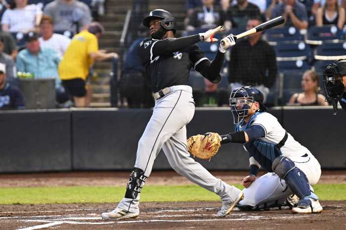 Luis Robert Jr. White Sox Mets: Baseball player in black uniform swings bat