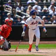 Mets' Brett Baty to play 'a bunch of different positions,' David Stearns says 9 Mets player watching a hit go into the outfield near a catcher in red gear Brett Baty
