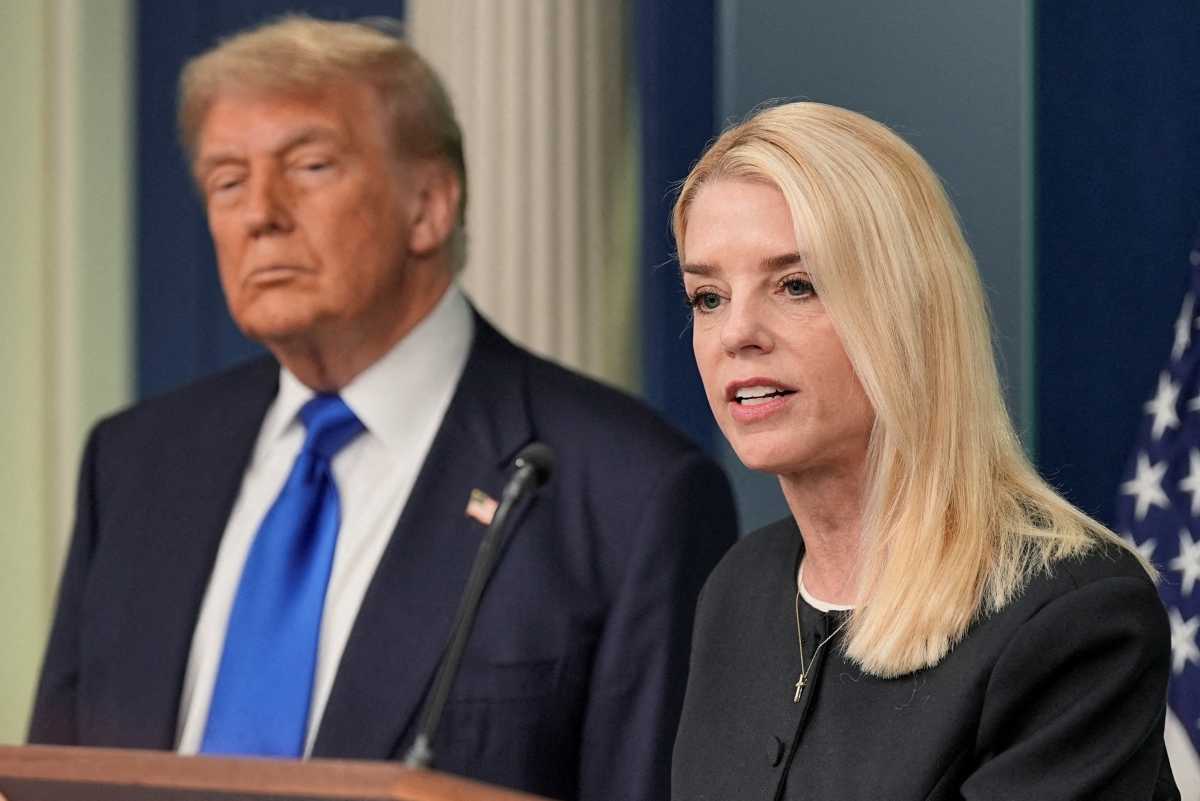 woman speaking at podium while man looks on