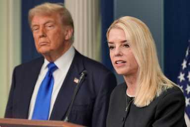 woman speaking at podium while man looks on