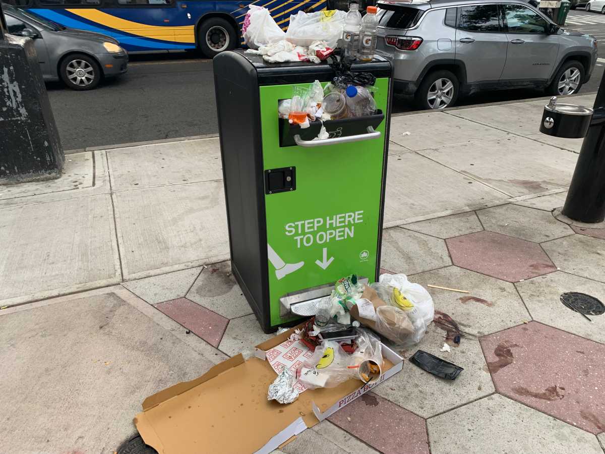 a public trash can that is overstuffed with garbage