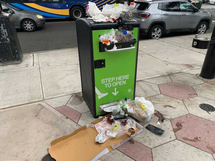 a public trash can that is overstuffed with garbage