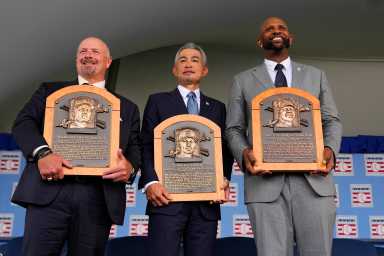 three retired baseball players holding hall of fame plaques.