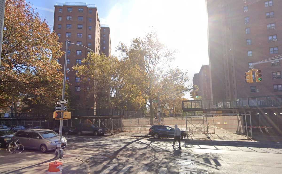 buildings on sunny day with man crossing street in foreground
