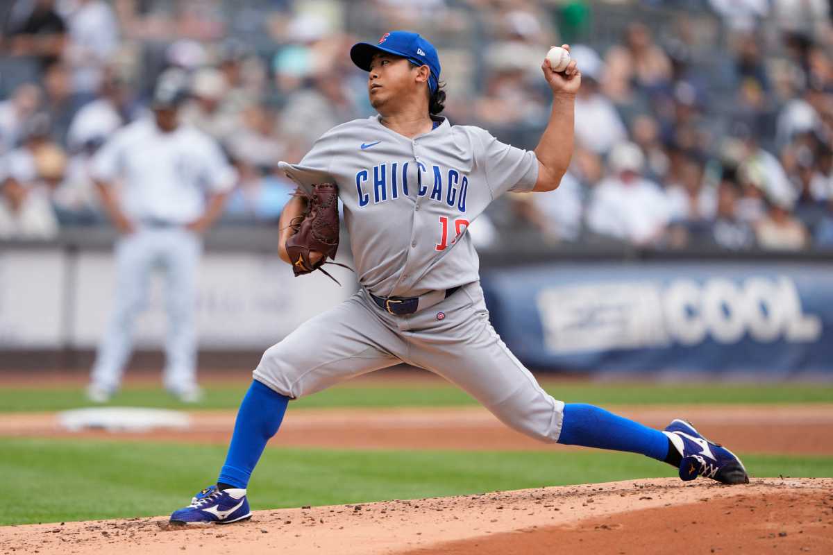 man in grey uniform with the word Chicago written in blue throws ball with left hadn