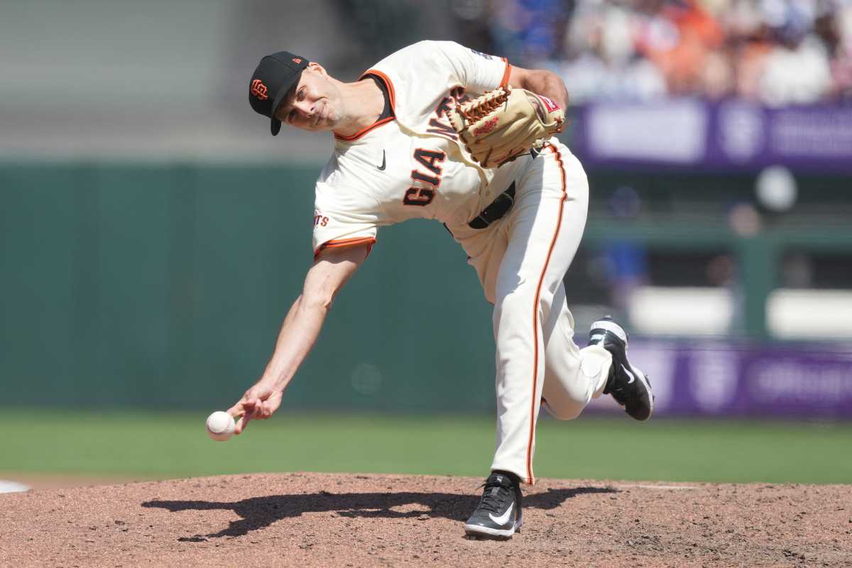 Tyler Rogers Mets trade: Baseball pitcher in white uniform and black hat delivers pitch submarine style