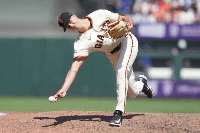 Tyler Rogers Mets trade: Baseball pitcher in white uniform and black hat delivers pitch submarine style