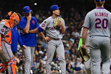 Kodai Senga Mets Brewers: Men in grey uniforms stand near pitcher's mound.