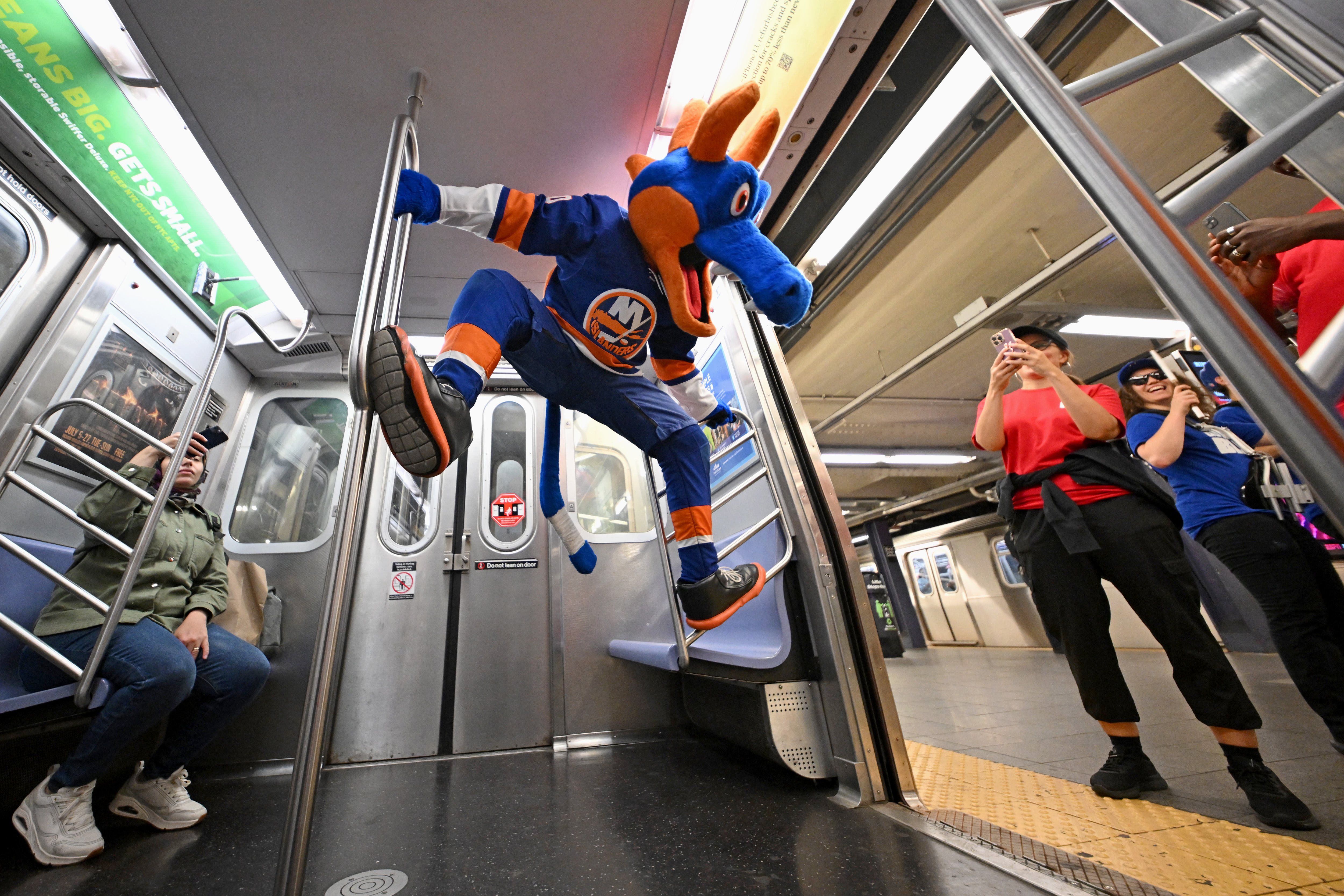 Sparky the Dragon, mascot for the New York Islanders, and commuters ride the ESPN "E" train celebrating the launch of the all-new ESPN app on August 21, 2025 in New York City. 