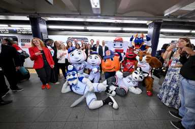 Jo Fox, Rosalyn Durant, Denise Pellegrini, Tina Thornton, Rita Ferro, Judy Agay, Jimmy Zasowski, Elle Duncan, Adam Smith, Chara-Lynn Aguiar, Burke Magnus, ESPN Chairman Jimmy Pitaro and notable tri-state area mascots take the inaugural ride of ESPN’s "E" train takeover celebrating the launch of the new ESPN app on August 21, 2025 in New York City.
