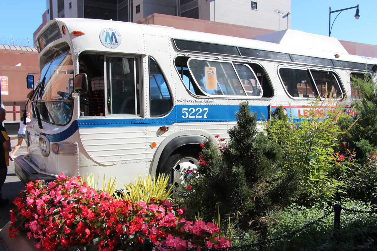 a vintage NYC bus at a bus festival in Brooklyn surrounded by flowers and plants