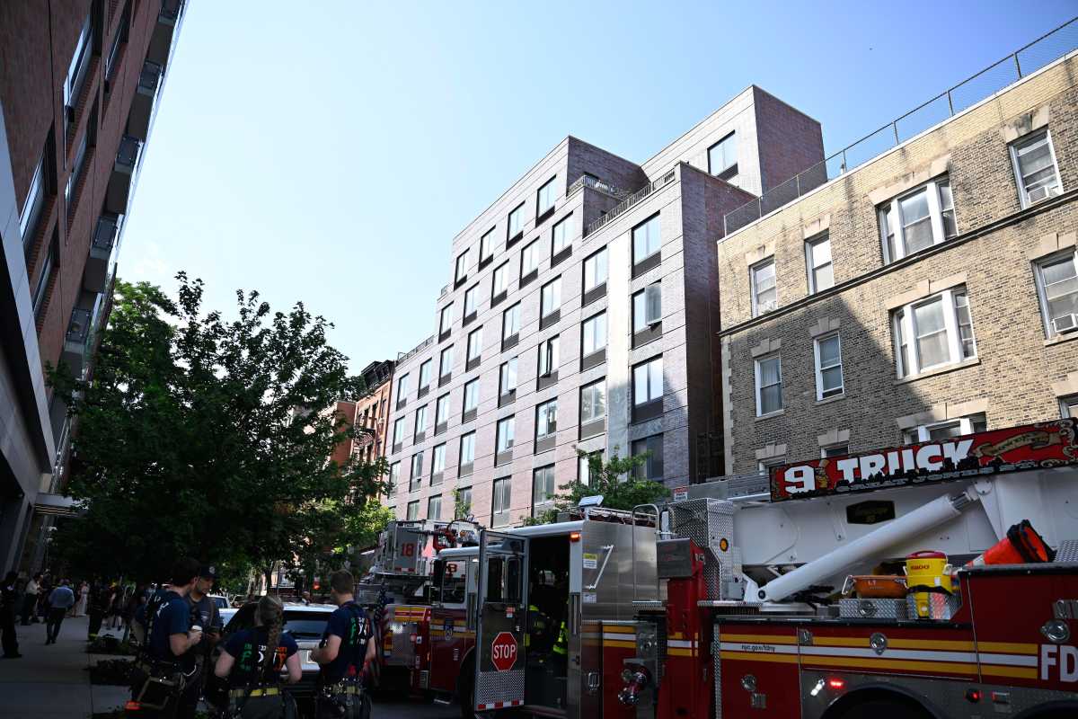 A firefighter works to beat the heat as temps were in the mid 90's during an afternoon blaze in the lower East side on Monday, July, 28.