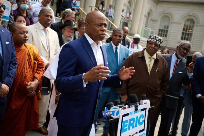 man speaking at Eric Adams for mayor rally at podium
