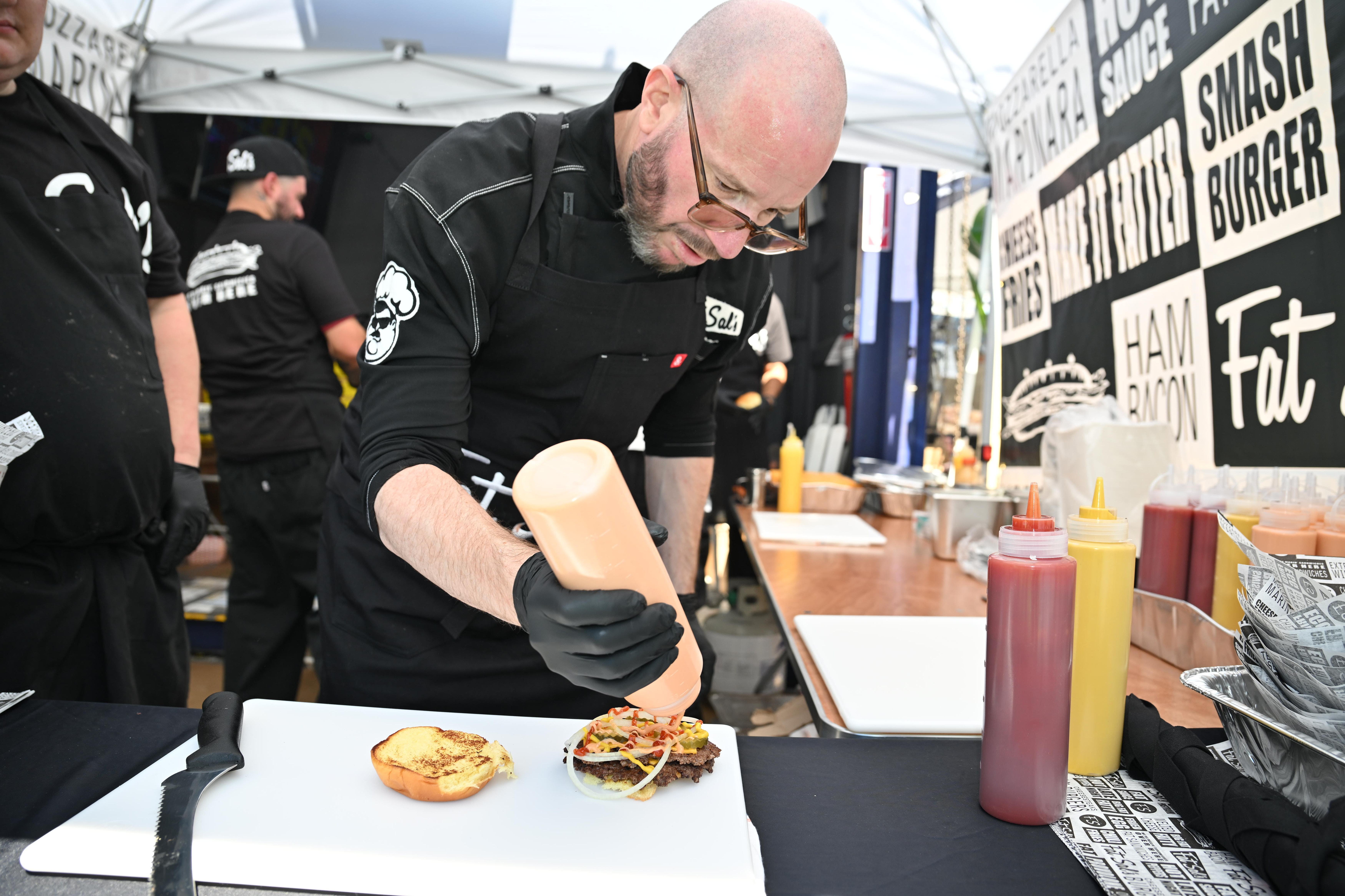 A member of Fat Sal's prepares a burger.