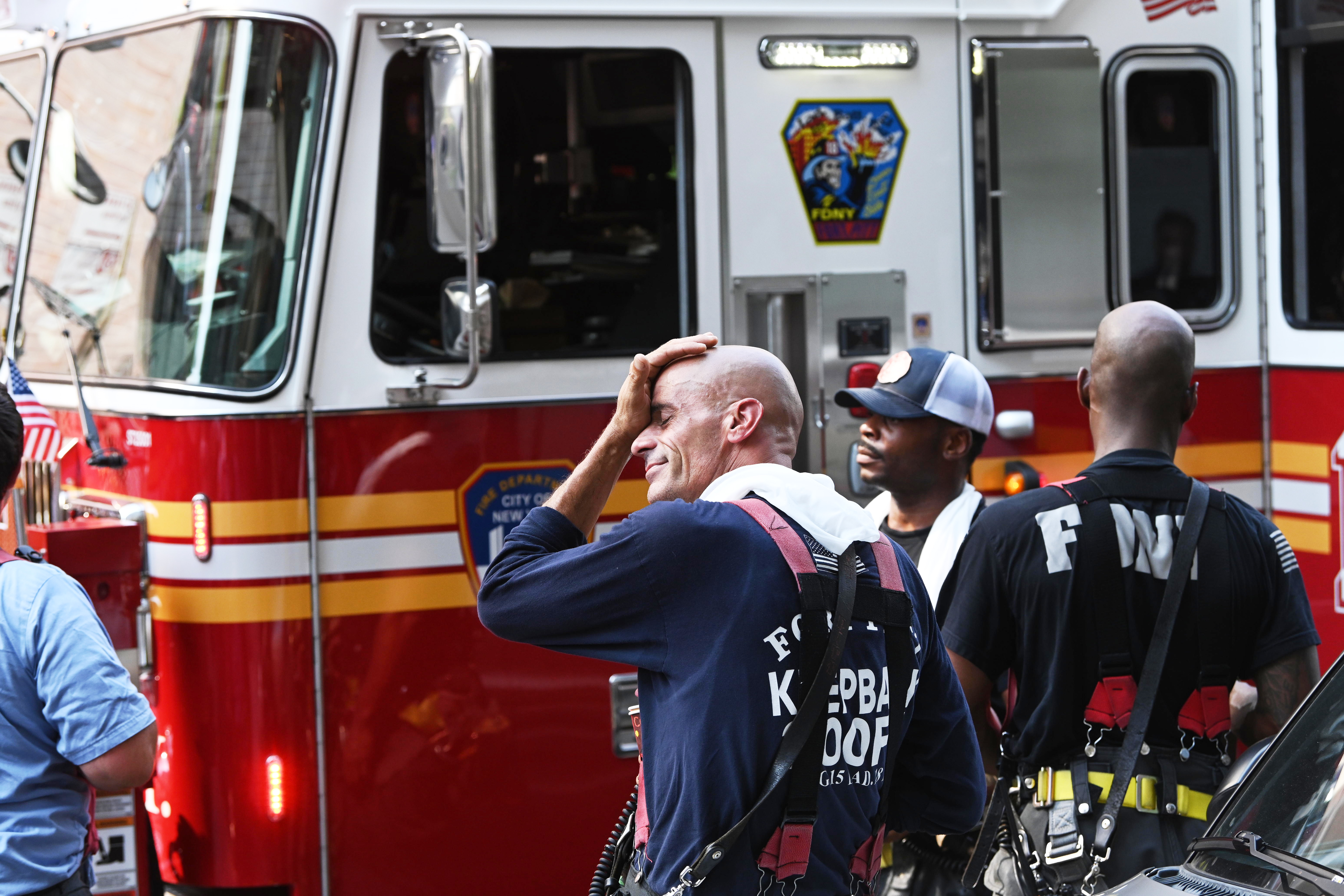 Firefighters try to cool off after a fire.