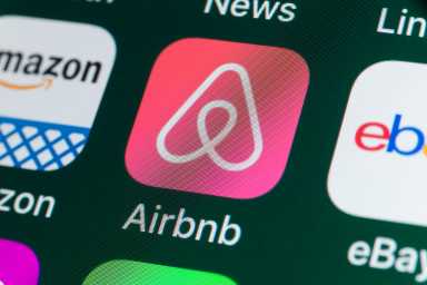 London, UK - July 31, 2018: The buttons of the travel app Airbnb, surrounded by Amazon, ebay, News and other apps on the screen of an iPhone.