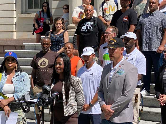 Nubia Ashley, owner of the women-led dispensary Residue, speaks at the City Hall rally, sharing how her fully built-out shop was barred from opening due to new proximity rules, leaving her in debt before even making a sale.