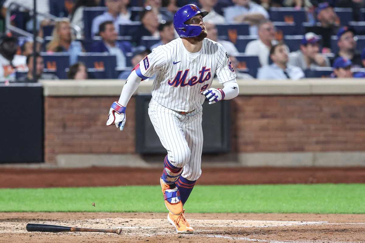 Brandon Nimmo Mets: Baseball player in white uniform looks up at ball while running