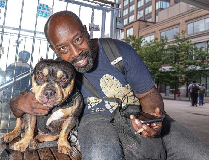 man smiling with his dog, reunited after being stolen from bronx train