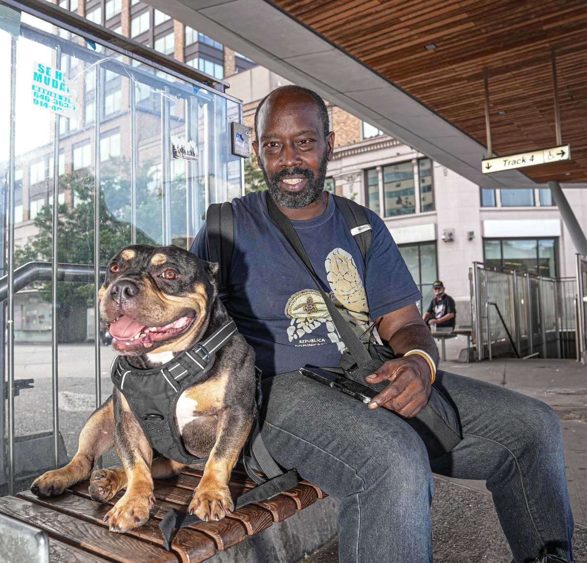man smiling with his dog, reunited after being stolen from bronx train