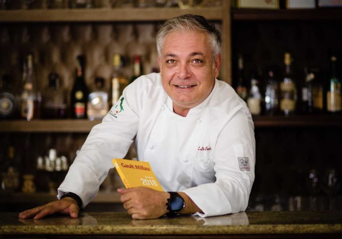 man in chef's outfit holding menu at CASASALVO restaurant in Soho
