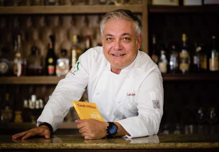 man in chef's outfit holding menu at CASASALVO restaurant in Soho