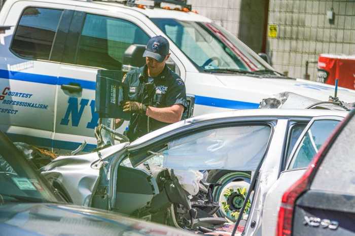 Police officers examine scene of a deadly Queens crash