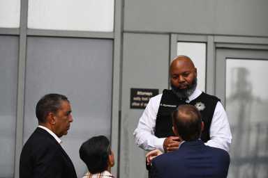 federal agent with ICE speaking with NYC Congress members at Brooklyn facility