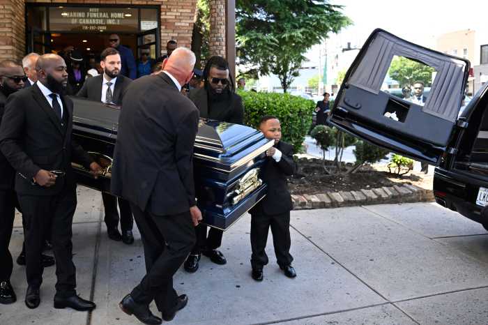 child and pallbearers carry casket of Midtown mass shooting victim