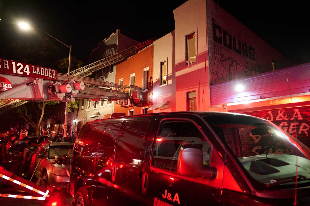 Brooklyn four-alarm fire leaves four firefighters and resident injured 2 firefighters with equipment in front of rowhouses in Brooklyn during fire