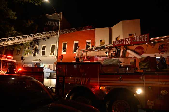 firefighters with equipment in front of rowhouses in Brooklyn during fire