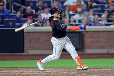 Francisco Alvarez injury Mets Mariners: Man in black uniform swings baseball bat