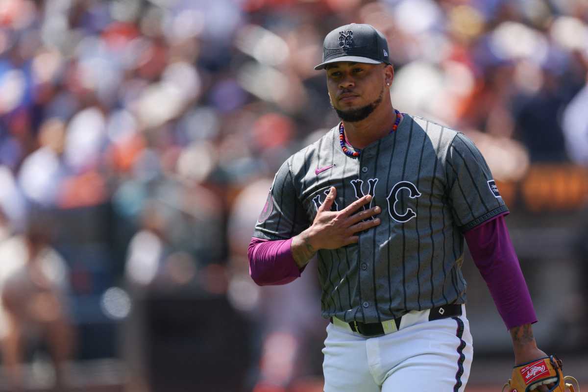 Frankie Montas Mets: Man in grey baseball uniform walks off field with hand on chest.