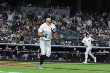Giancarlo Stanton Yankees home run Twins: Man in pinstriped uniform runs toward first base after hitting home run