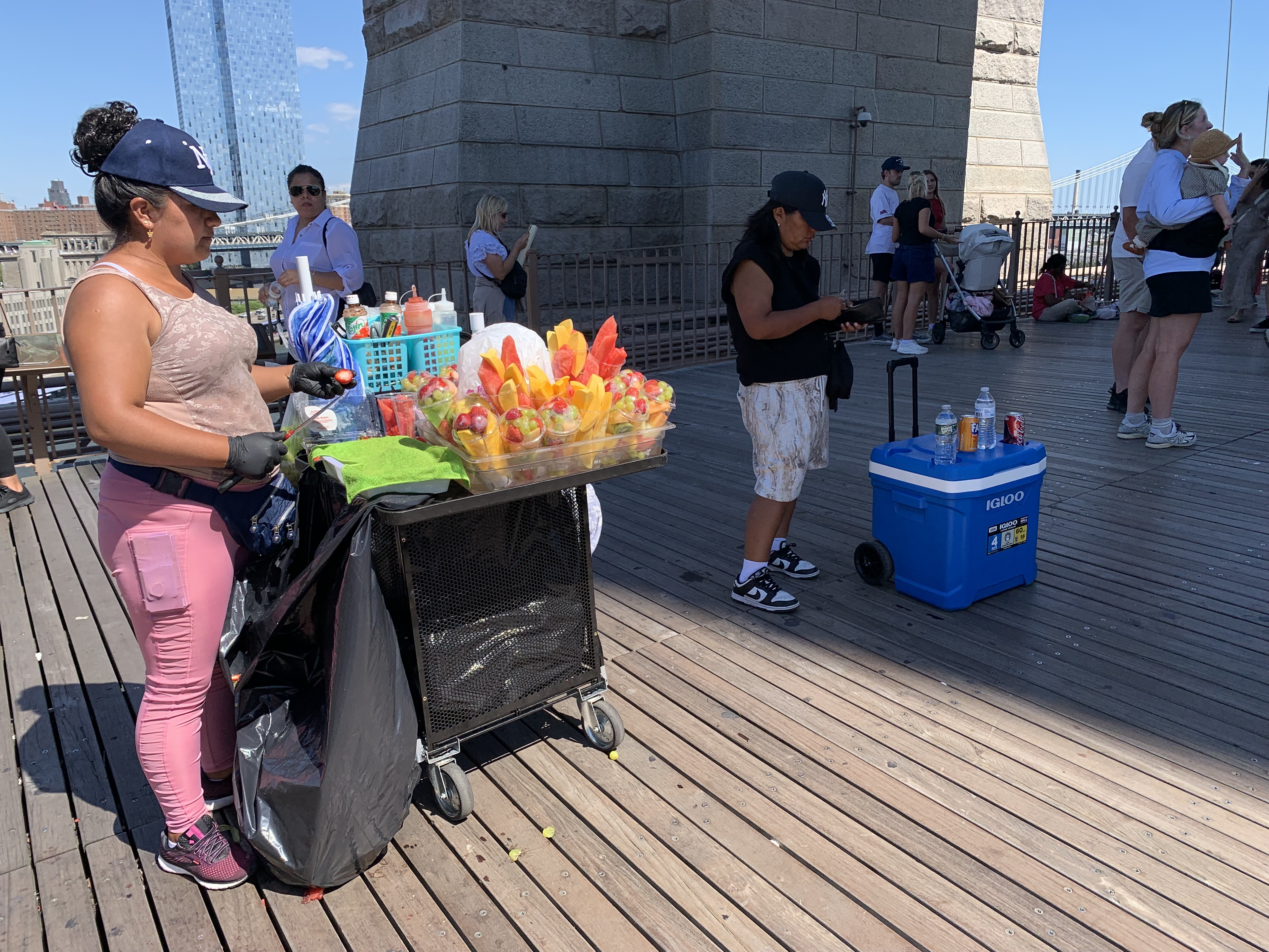 Sales pressure: Policing, policy, and a push for fair street vending in NYC 2 people selling items on a bridge with a wooden floor