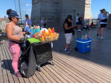people selling items on a bridge with a wooden floor