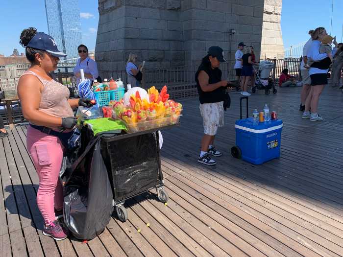 people selling items on a bridge with a wooden floor