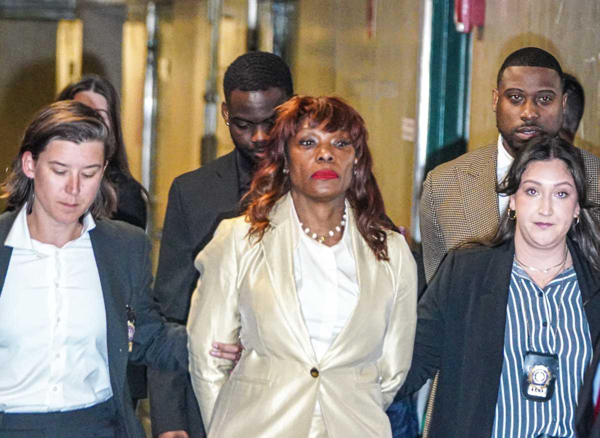 woman in handcuffs escorted by detectives after corruption indictment