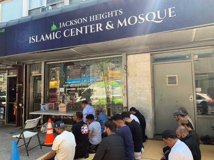 Men praying outside an Islamic Center and Mosque