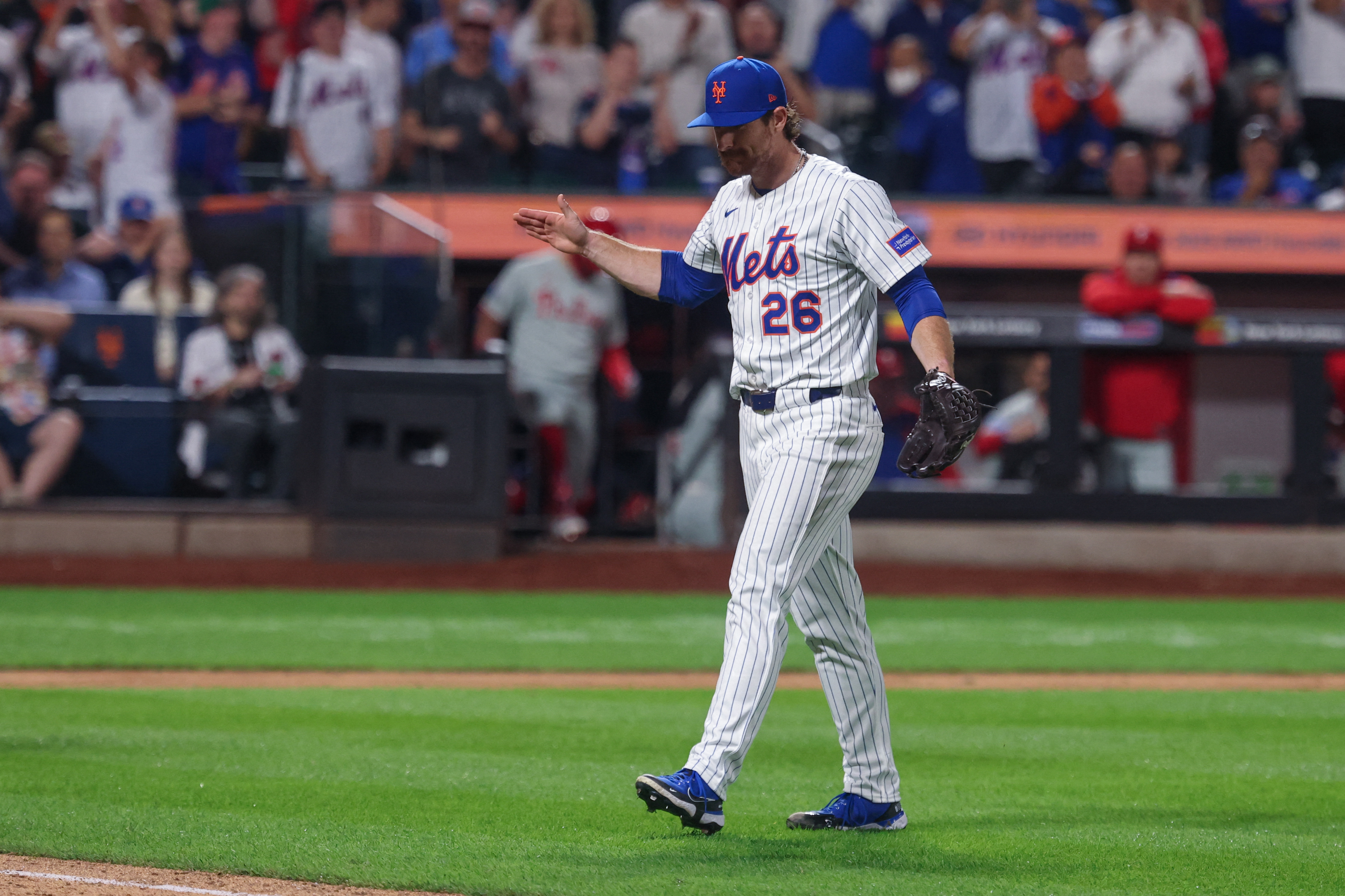 Nolan McLean claps hands as he walks to dugout Mets