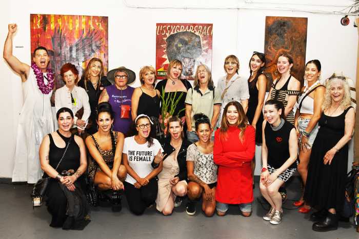 women standing in group photo at art exhibit Relentless women