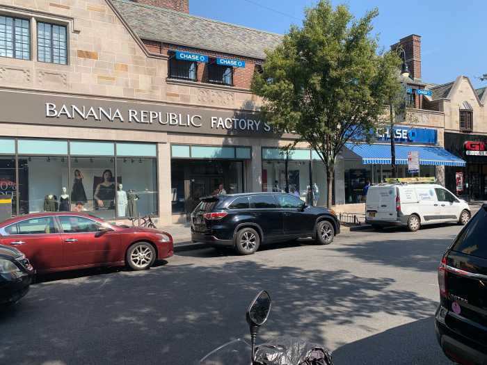 commercial shopping on street with parked cars