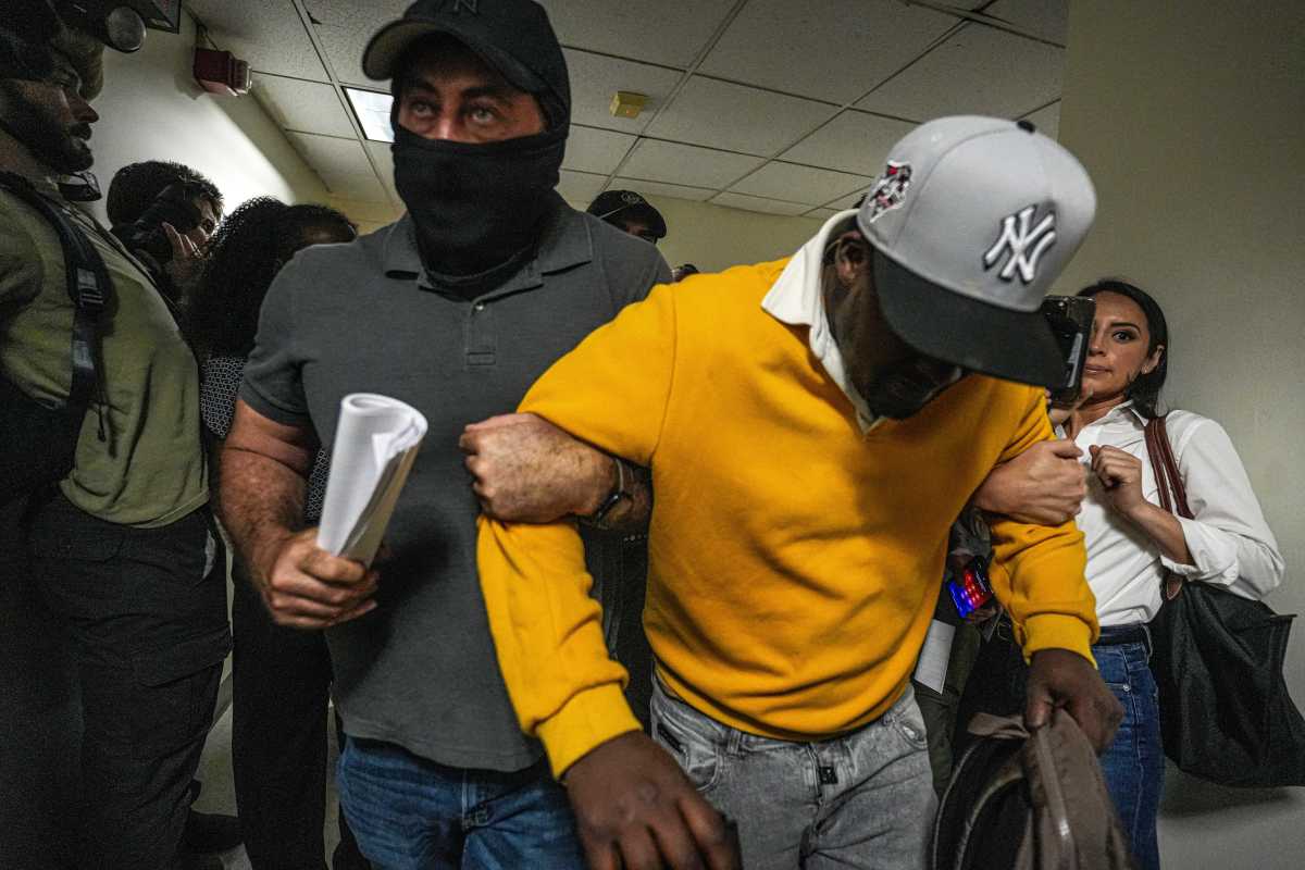man bows while being dragged away by ICE agent
