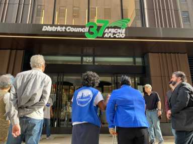 Retired and active city workers rally outside District Council 37 headquarters in Lower Manhattan on Tuesday, protesting the Municipal Labor Committee’s approval of a new self-funded health insurance plan. Demonstrators expressed concern over the plan’s secrecy, potential cost increases, and reduced member input.